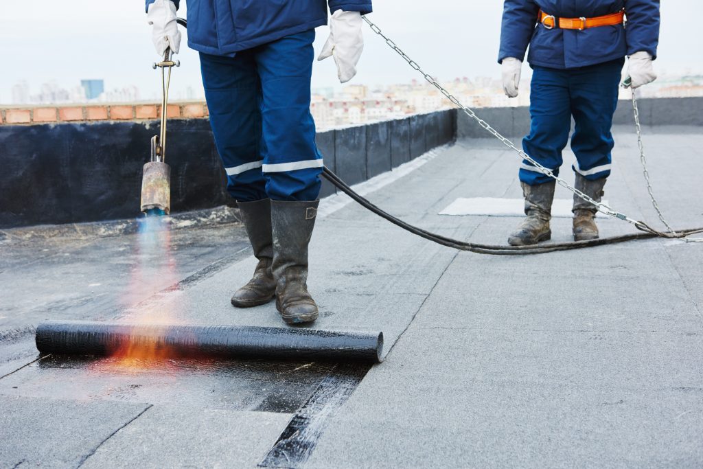 Worker installing a built-up roof