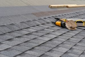 Toolbelt and nail gun laying on unfinished roof