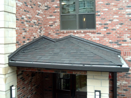 Composition roofing over a building entranceway