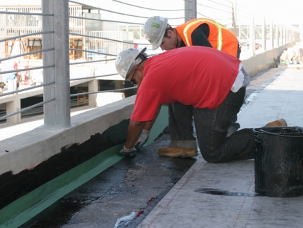 McDonald & Wetle employees waterproof a commercial building roof